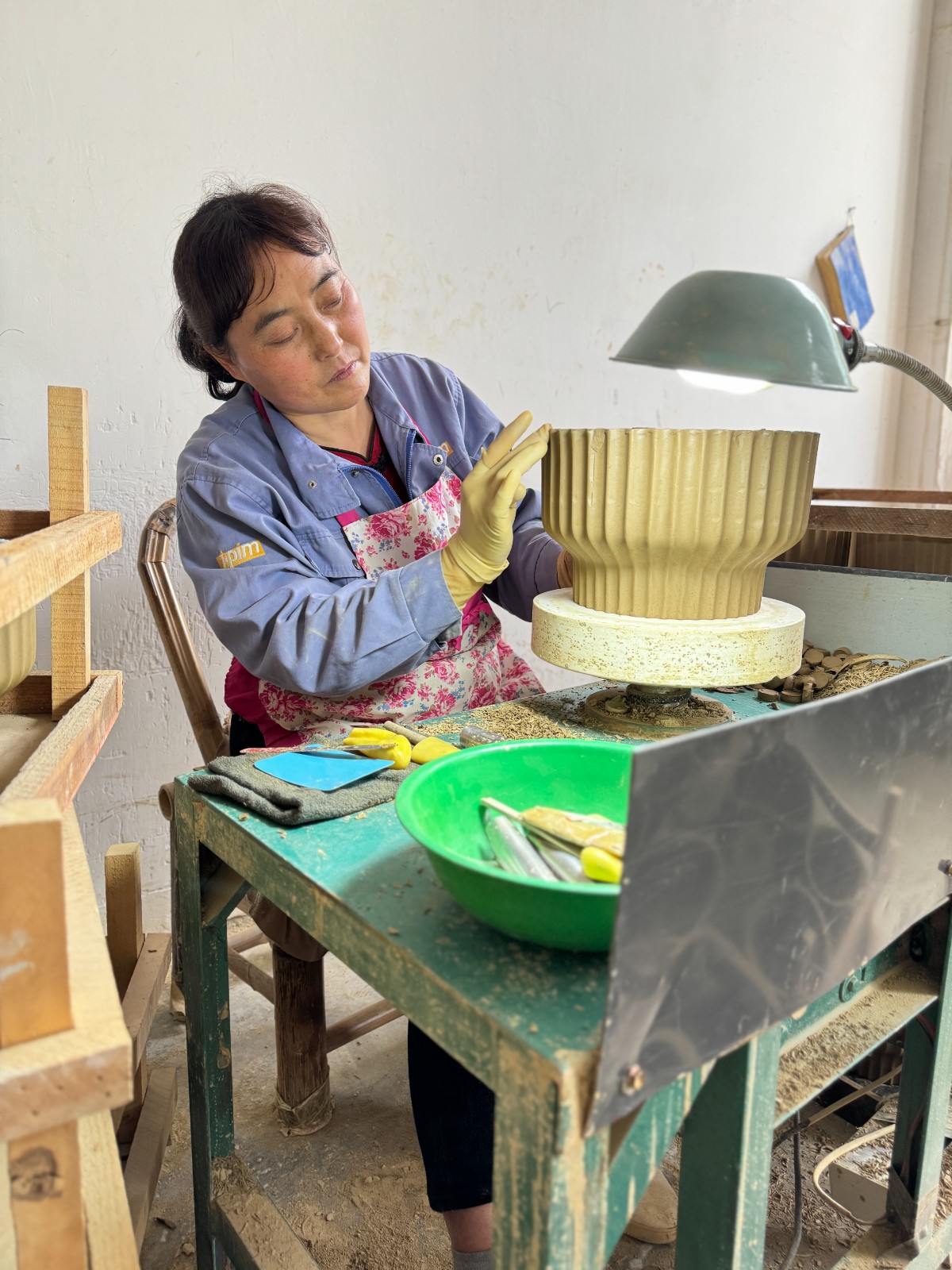 在秦熙禾陶業(yè)有限公司里，女工正在進(jìn)行陶器修胚工序。.jpg